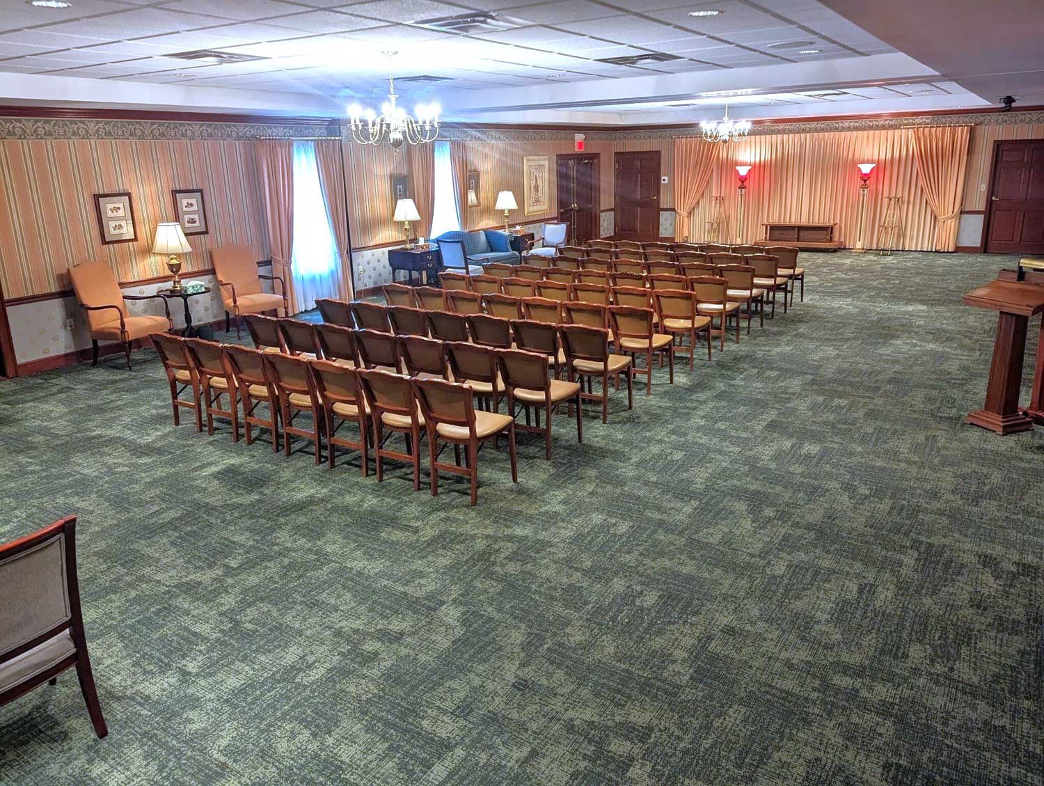 The rear view of the main chapel featuring elegant chandeliers and a carpeted floor.